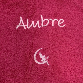 Broderie prénom Ambre avec motif fée sur serviette de bain fuchsia